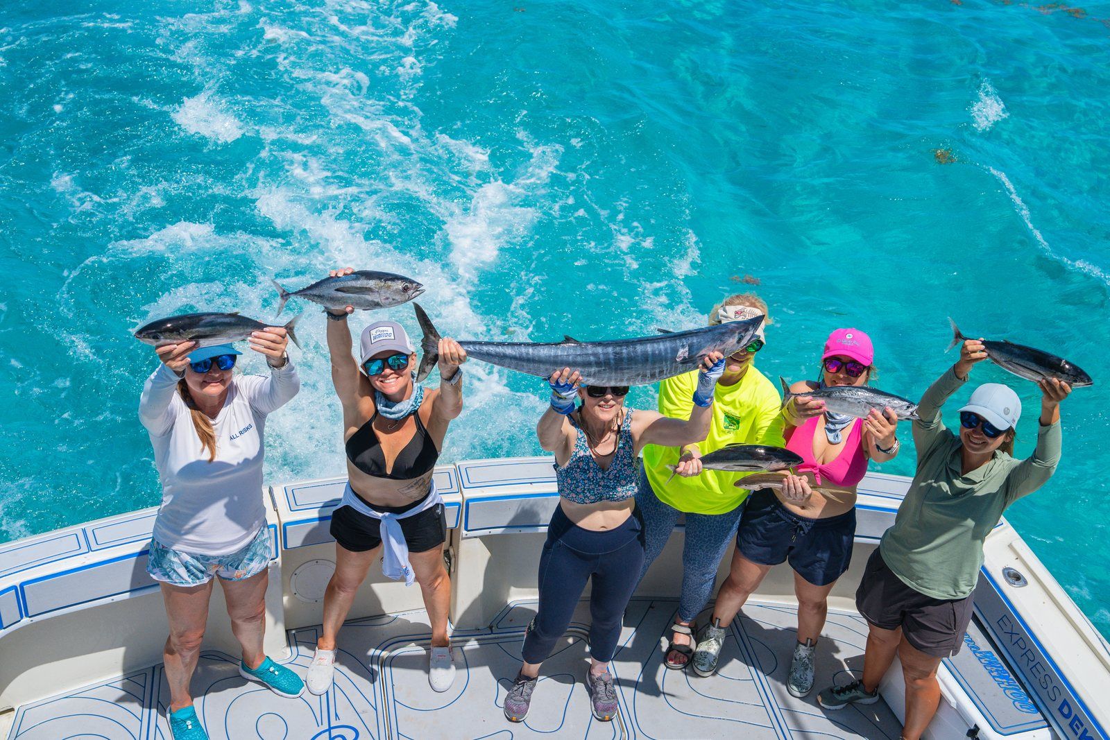 An angler lifting a wahoo on the bow of a Poppa Wahoo Collective boat off Islamorada