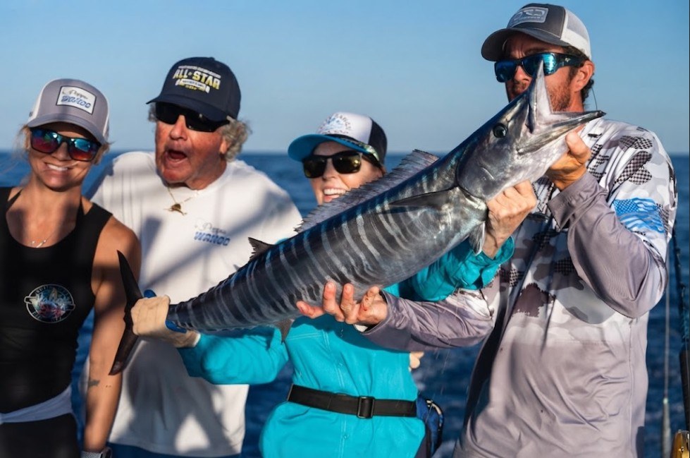 The crew holding a big wahoo, Capt. Skip in the middle of it